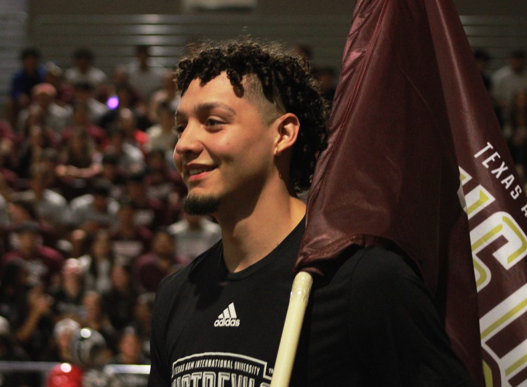 Olaverr Camacho holds a flag during Maroon Madness.